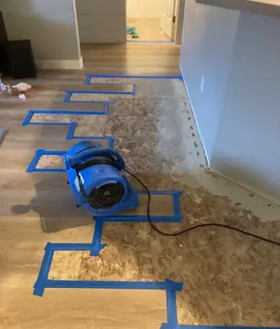 Air mover drying a taped-off wet floor in a Miami Beach unit