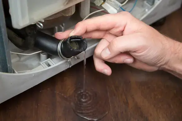 Water dripping from a failed washing machine hose in a Miami Beach laundry