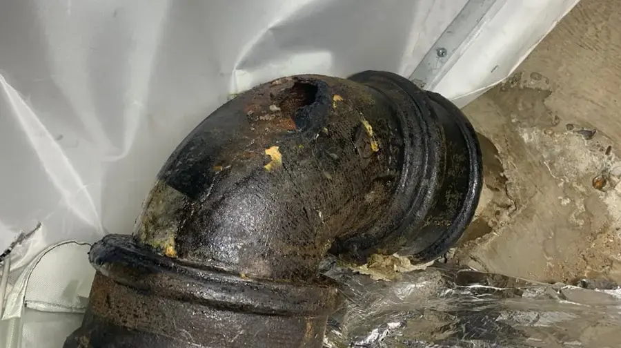 Corroded cast iron drain pipe leaking in a Miami Beach building