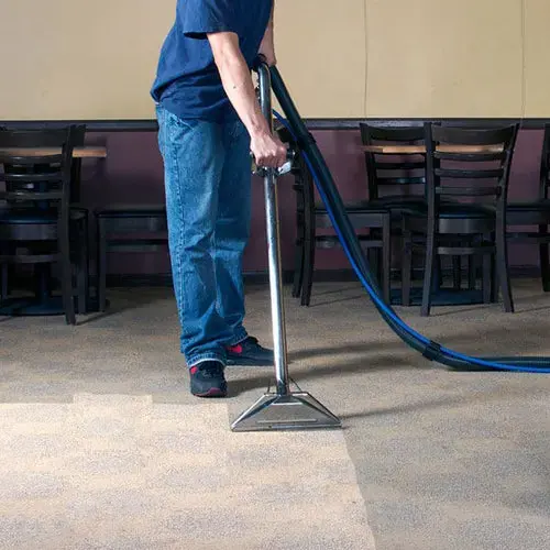 Extraction wand pulling water out of wet carpet during a Miami Beach water extraction